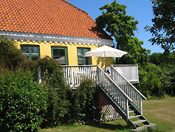 Sommerhaus  BODERNE FERIE 
 Auf einem bezaubernden historischen Hof bieten wir eine große,helle Ferienwohnung mit Blick auf die Ostsee.
St. Loftsgaard liegt im südlichen Teil von Bornholm im
idyllischen Dorf Boderne.
Hier gibt es Eis, eine Kaffeebar, einen herrlichen Sandstrand, einen kleinen Hafen und ein Bekleidungsgeschäft.
Die Geschichte von Store Loftsgaard läßt sich weit zurückverfolgen, der Hof existiert seit dem Altertum.
Store Loftsgaard ist seit dem Jahr 1598 bewohnt.
Die Wände im Keller stammen noch aus der damaligen Zeit 
und wurden aus Stein und Lehm gefertigt.
Die Wände der Stuben wurden 1880 errichtet und stehen noch heute.
Hier kommt gemütliche Stimmung auf.
Der kleine Grødby-Bach fließt durch unseren Garten.
Darin findet man eine Hängematte zwischen den Bäumen, ein Trampolin, Schaukeln, 
einen Sandkasten, ein Spielhaus, Fußballtore für die Größeren und jede Menge Platz. Hier treffen Sie auf Wild, Kaninchen und Fasane.